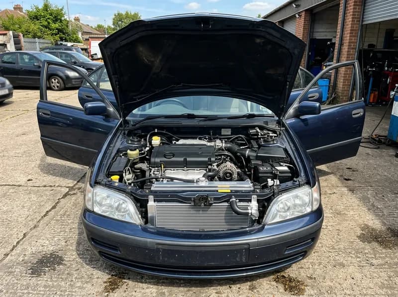 O motor aberto de uma berlina escura